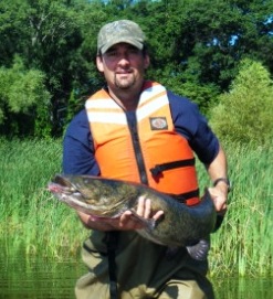 Scott Kendall holding a Flathead Catfish in Muskegon Lake